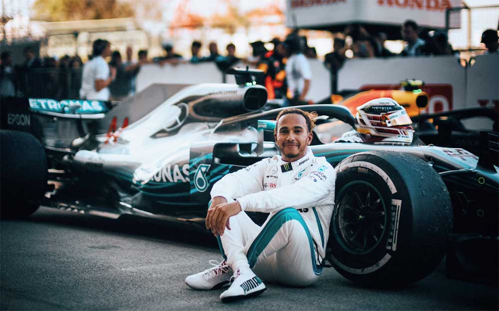 優勝しマシンの脇で満足げな表情を浮かべるメルセデスのルイス・ハミルトン、F1日本グランプリ 2018年10月7日