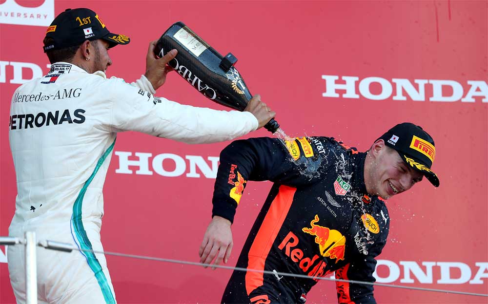 F1日本グランプリの表彰台でシャンパンファイトに興じるルイス・ハミルトンとマックス・フェルスタッペン、2018年10月7日