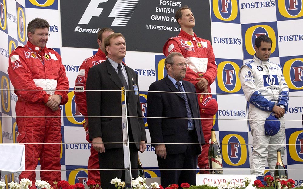 2002年のF1イギリスGPの表彰台に上がったフェラーリのミハエル・シューマッハとルーベンス・バリチェロ、ウィリアムズのファン・パブロ・モントーヤ
