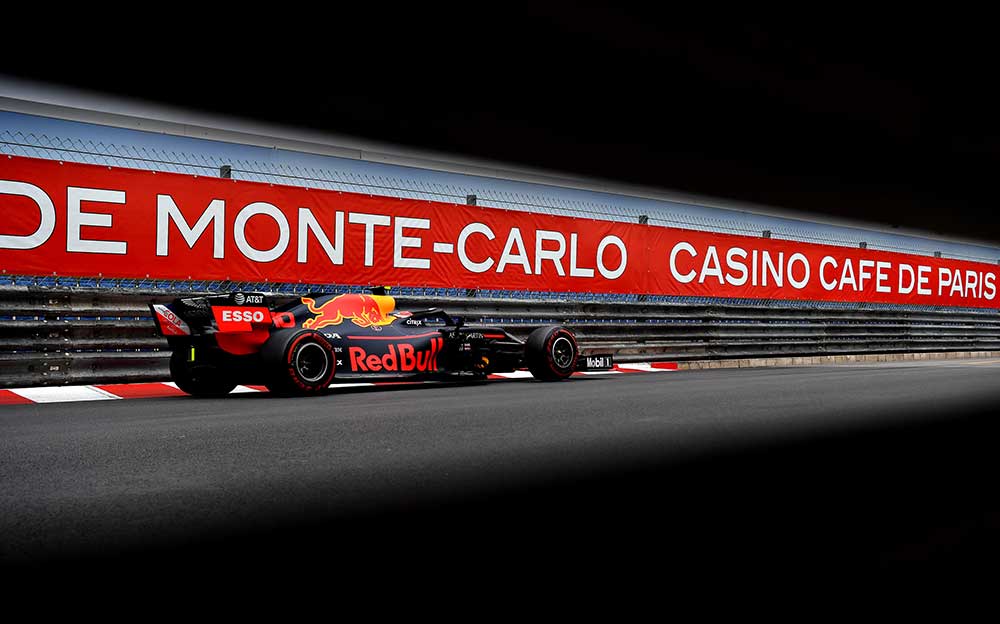 モンテカルロのバナーを背景にF1モナコGP決勝レースを走るレッドブル・ホンダRB15