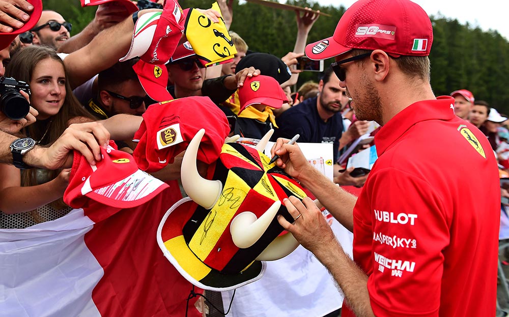 ファンのサインの求めに応じるフェラーリのセバスチャン・ベッテル