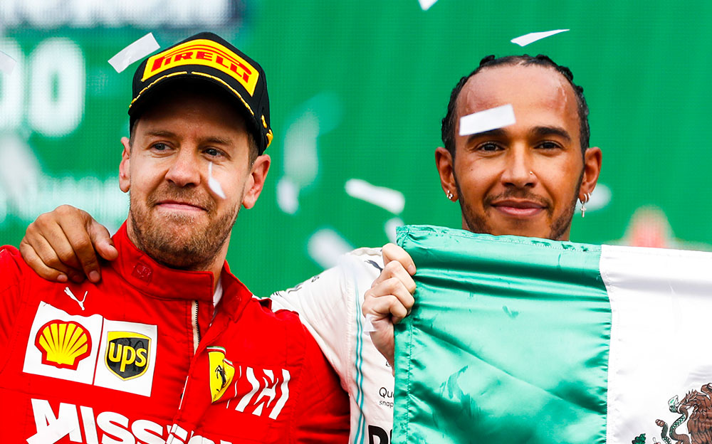 方を抱き合うセバスチャン・ベッテルとルイス・ハミルトン、2019年F1メキシコGP表彰台セレモニーにて