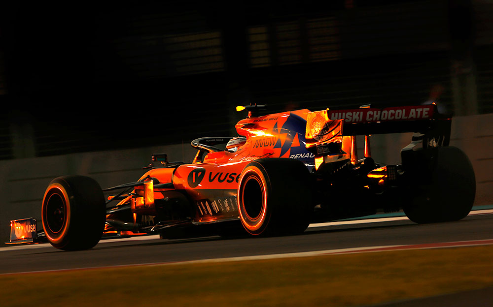 強烈なオレンジ色の夕日に照らされるマクラーレンMCL34をドライブするランド・ノリス、2019年F1アブダビGPにて