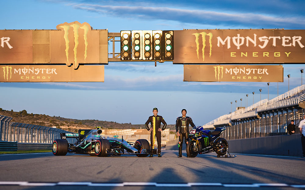 バレンシアサーキットのホームストレートに立つバレンティーノ・ロッシとルイス・ハミルトン及びメルセデスW08とヤマハYZR-M1