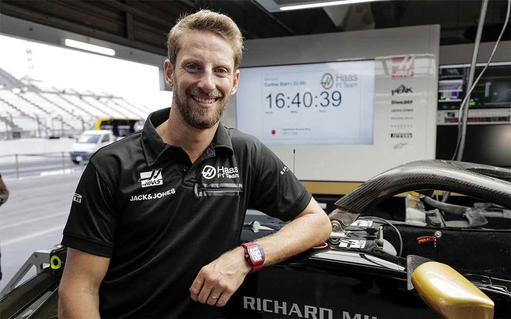 マシンに肘をついて笑顔を見せるハースF1チームのロマン・グロージャン、2019年