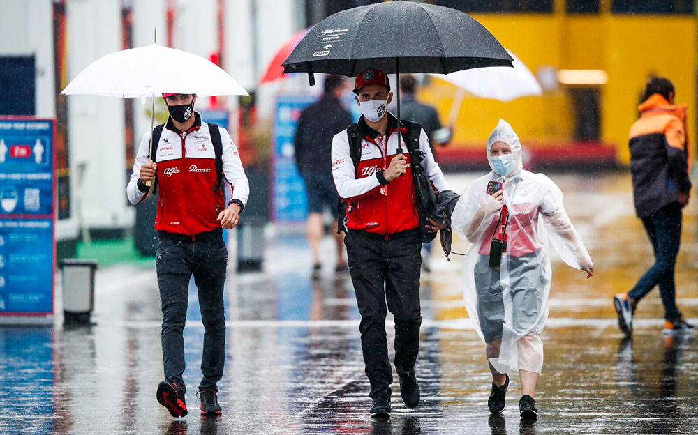 雨のパドックを歩くアルファロメオのスタッフ、2020年F1シュタイアーマルクGP 2日目