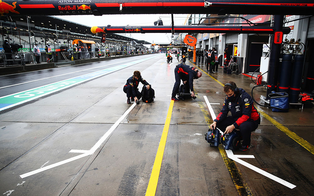 ガレージ前の路面を乾かそうとするレッドブル・ホンダのチームメンバー、2020年F1アイフェルGP初日にて