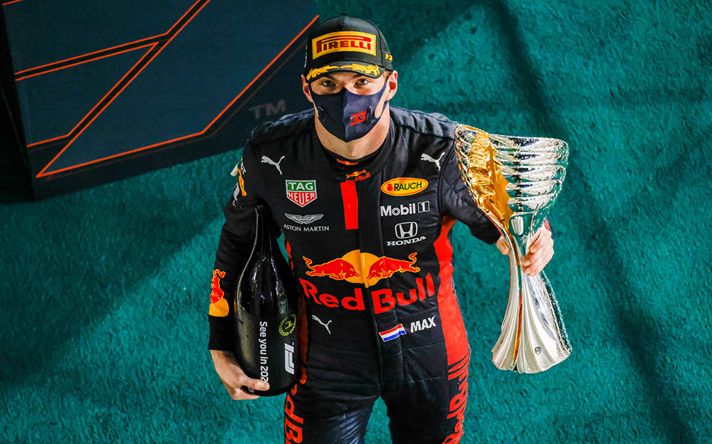 2020年F1アブダビGPの優勝トロフィーとシャンパンを持つレッドブル・ホンダのマックス・フェルスタッペン