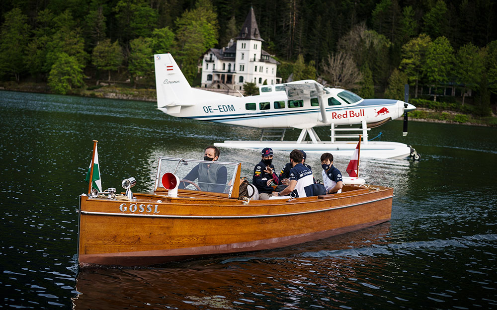 ザルツカンマーグート地方の伝統的な木製ボートの「Plätte」に乗るレッドブル・ホンダのマックス・フェルスタッペンとセルジオ・ペレス、アルファタウリ・ホンダのピエール・ガスリーと角田裕毅、2021年5月15日オーストリア・グルンドルゼーにて
