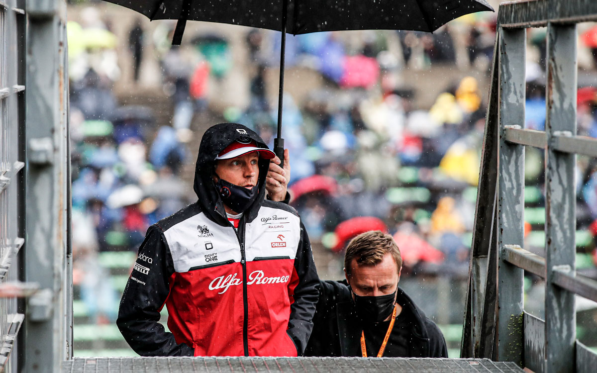 雨のスパ・フランコルシャンのパドックを歩くアルファロメオのキミ・ライコネン、2021年8月29日F1ベルギーGPにて