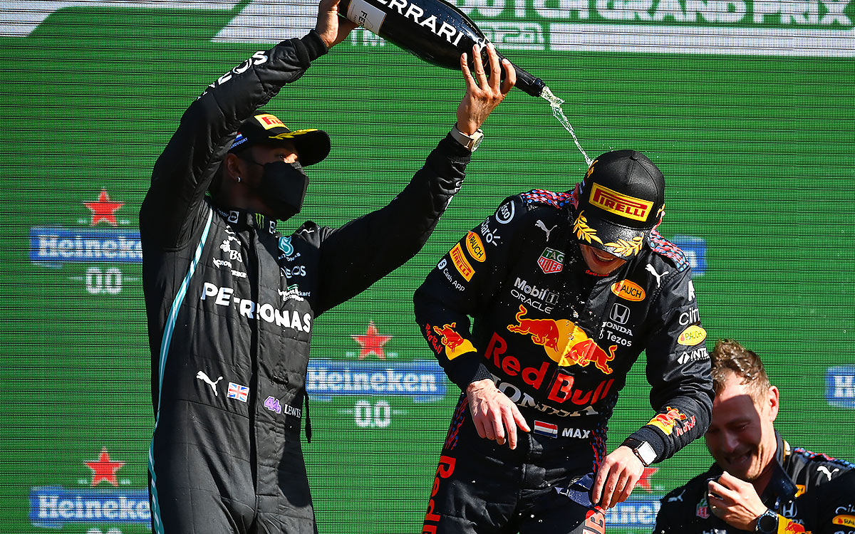 優勝したマックス・フェルスタッペン（レッドブル・ホンダ）にシャンパンをかけるルイス・ハミルトン（メルセデス）、2021年9月5日F1オランダGP決勝レースの表彰台セレモニーにて
