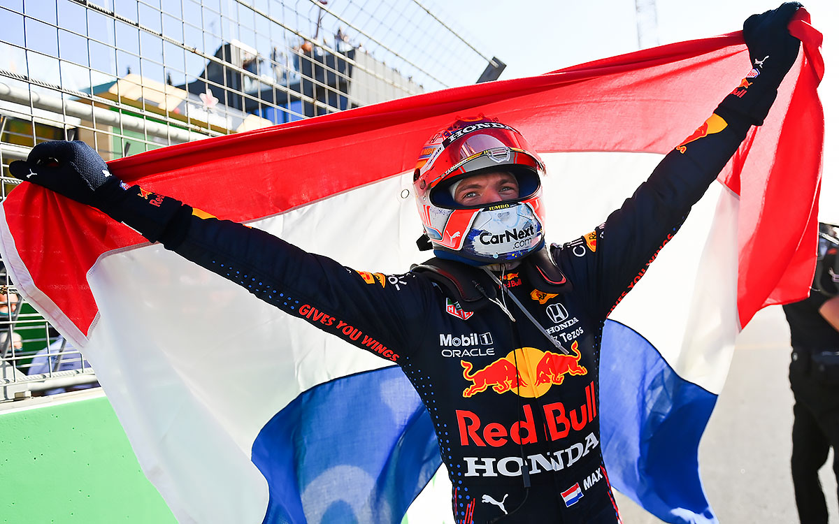 母国優勝を成し遂げオランダ国旗を背負うレッドブル・ホンダのマックス・フェルスタッペン、2021年9月5日F1オランダGP決勝レースにて