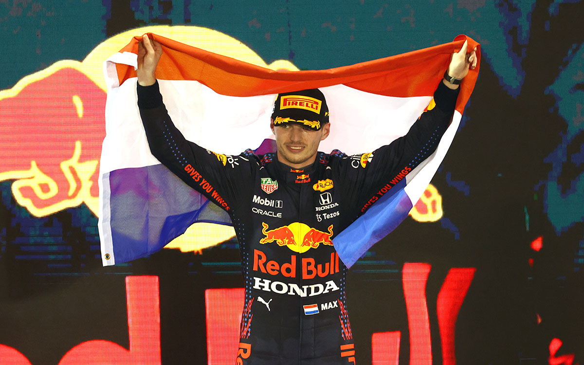 F1アブダビGPでのポール・トゥ・ウインを以て自身初のF1ワールドチャンピオン獲得を決め、表彰台の上でオランダ国旗を掲げるマックス・フェルスタッペン、2021年12月12日ヤス・マリーナ・サーキットにて