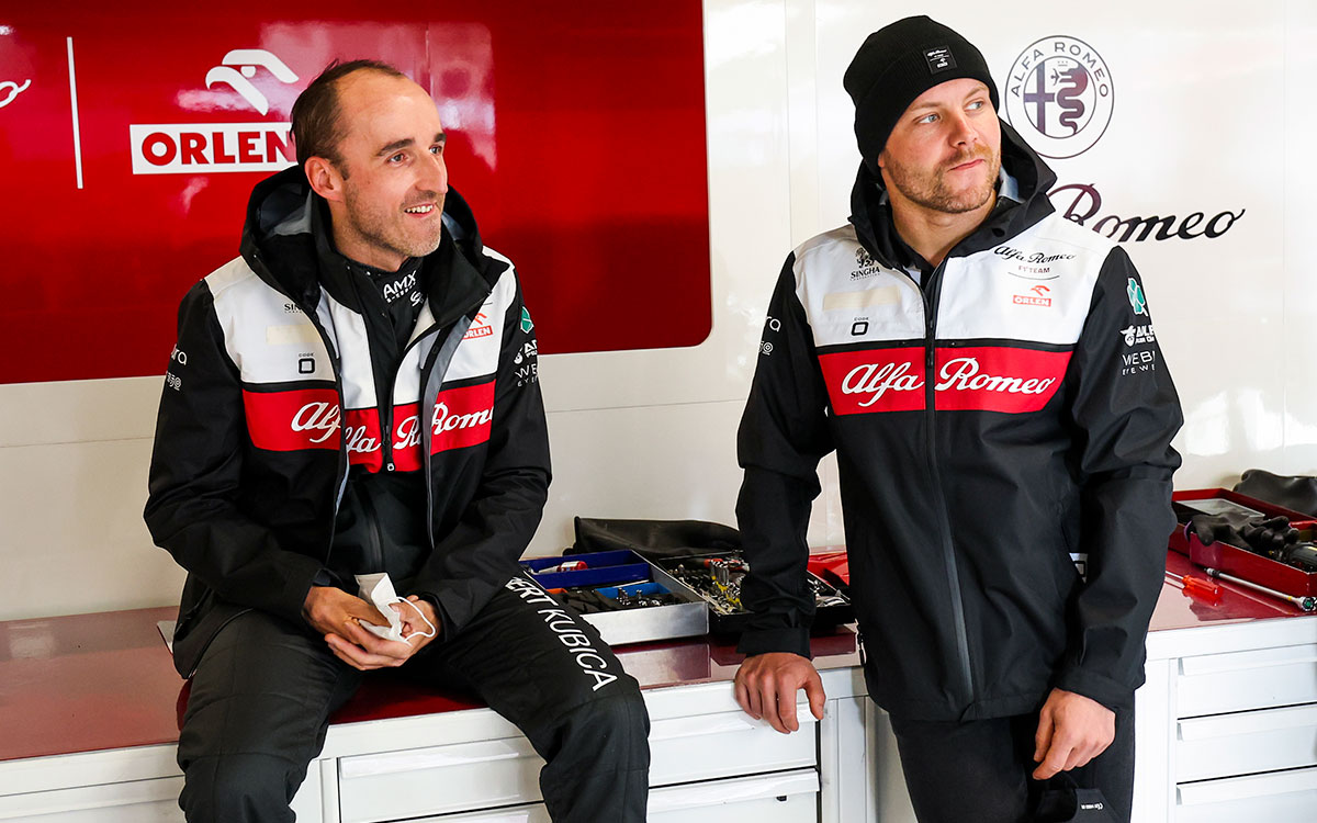 ガレージ内で談笑するアルファロメオのロバート・クビサとバルテリ・ボッタス、2022年2月23日F1バルセロナテスト初日