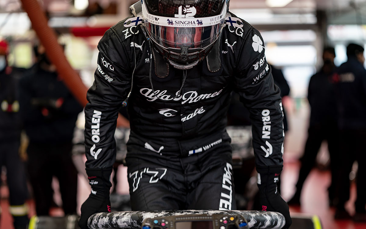 漆黒のレーシングスーツを着用し、白黒の迷彩柄でカモフラージュされたアルファロメオ「C42」に乗り込むバルテリ・ボッタス、2022年2月15日フィオラノ・サーキット