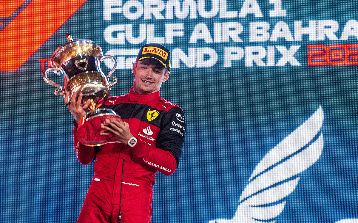 表彰台の上で優勝トロフィーを持つスクーデリア・フェラーリのシャルル・ルクレール、2022年3月20日F1バーレーンGP