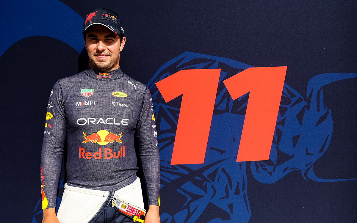 自身のカーナンバー「11」のガレージグラフィックを前にポーズを取るレッドブル・レーシングのセルジオ・ペレス、2022年3月11日F1バーレーンテスト