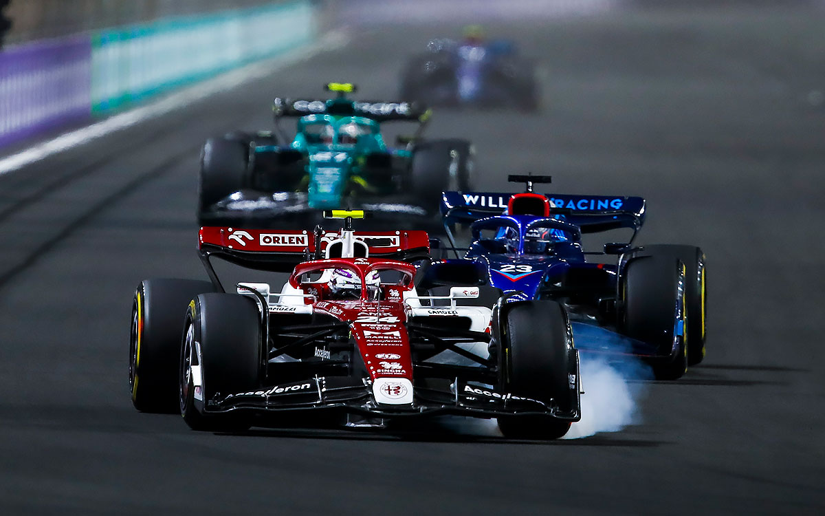 ウィリアムズのアレックス・アルボンとのバトルの最中にタイヤスモークを上げてブレーキングするアルファロメオの周冠宇、2022年3月27日F1サウジアラビアGP決勝レース