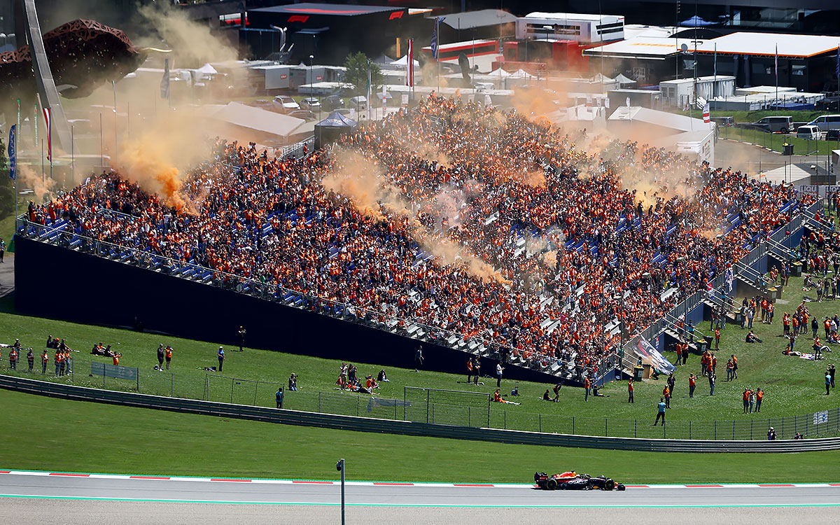 オレンジ色の発煙筒を上げるマックス・フェルスタッペン（レッドブル）の応援団、2022年7月8日F1オーストリアGP予選
