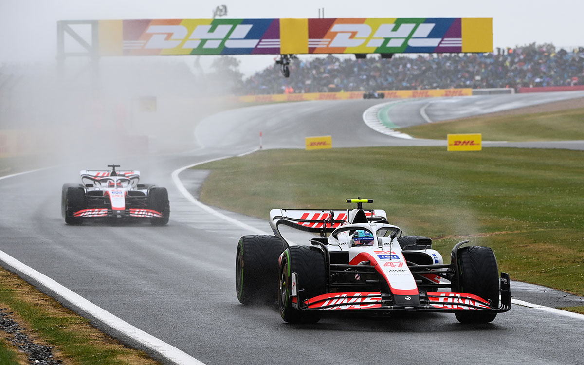 雨のシルバーストン・サーキットでピットレーンに進入するハースのミック・シューマッハとケビン・マグヌッセン、2022年7月2日F1イギリスGP予選
