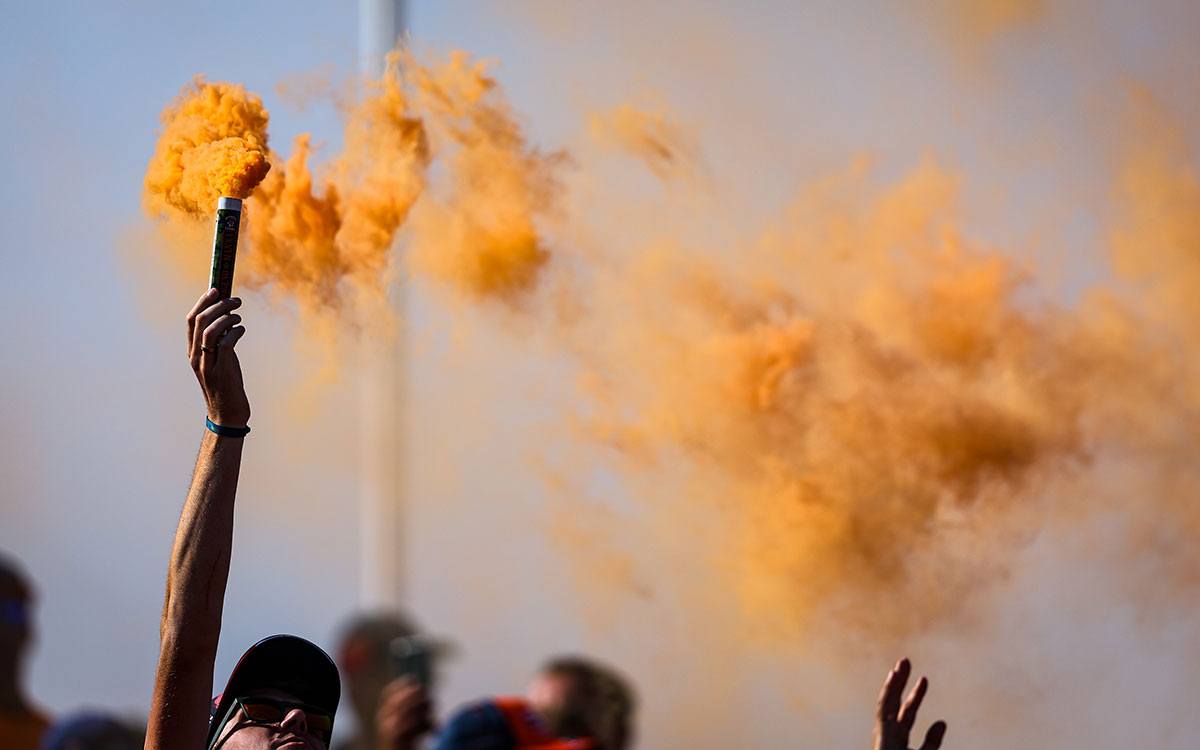 オレンジ色の煙を吐く発煙筒を掲げるF1オランダGPの観戦者、2022年9月2日