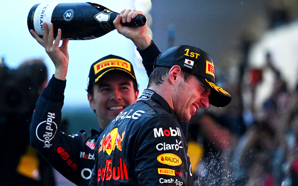 優勝してチャンピオンを勝ち取ったマックス・フェルスタッペン（レッドブル）にシャンパンをかけるセルジオ・ペレス、2022年10月9日F1日本GP