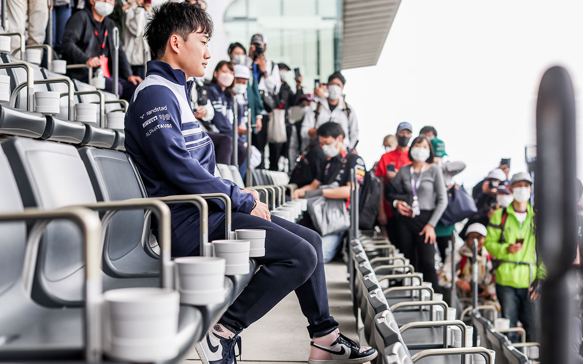 Netflixの撮影のためにグランドスタンドに座る角田裕毅（アルファタウリ）、2022年10月5日F1日本GP 鈴鹿サーキットにて
