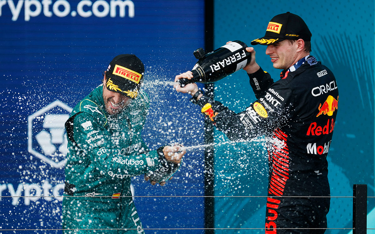 3位表彰台に上がったフェルナンド・アロンソ（アストンマーチン）にシャンパンをかけるレースウィナーのマックス・フェルスタッペン（レッドブル）、2023年5月7日F1マイアミGP決勝レース