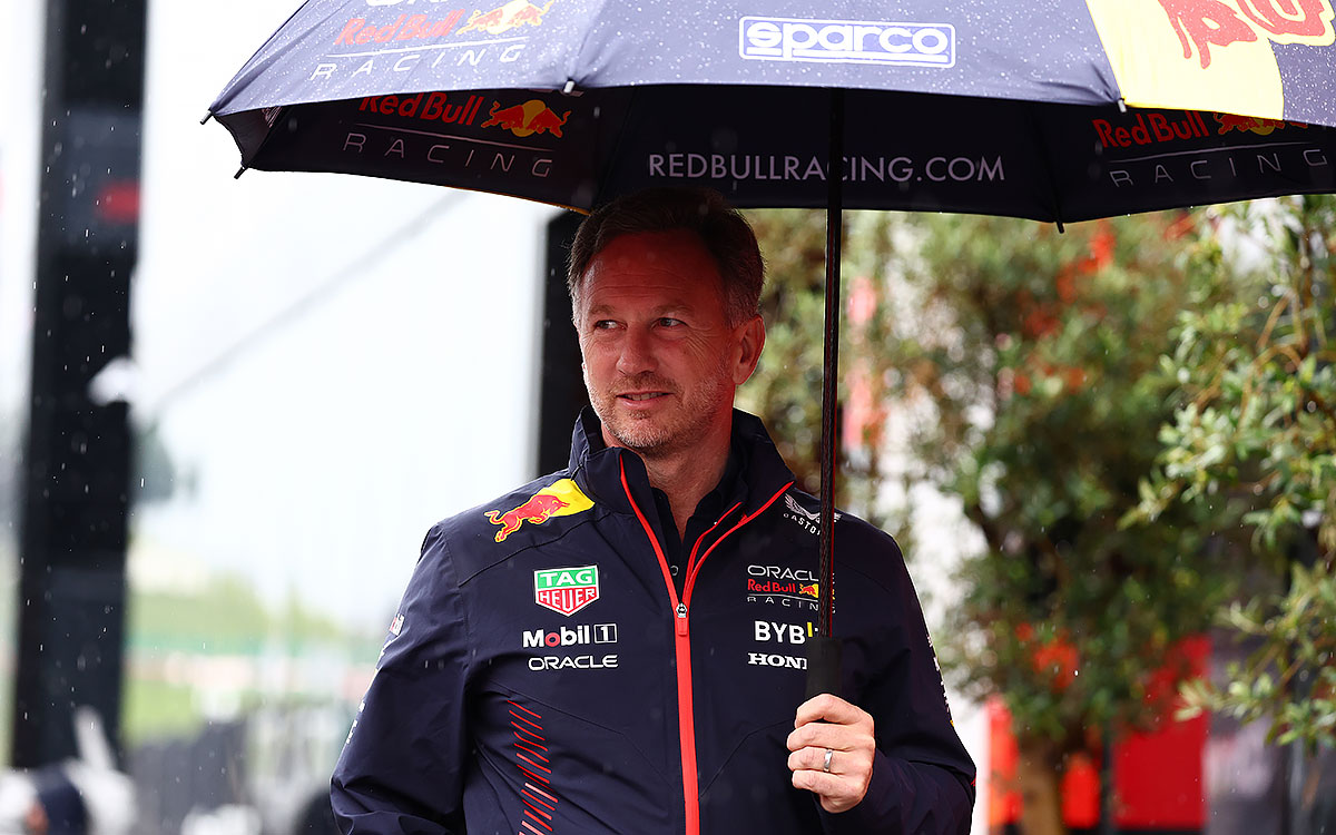 傘を差してレッドブル・リンクのパドックを歩くレッドブル・レーシングのクリスチャン・ホーナー代表、2023年7月1日F1オーストリアGP
