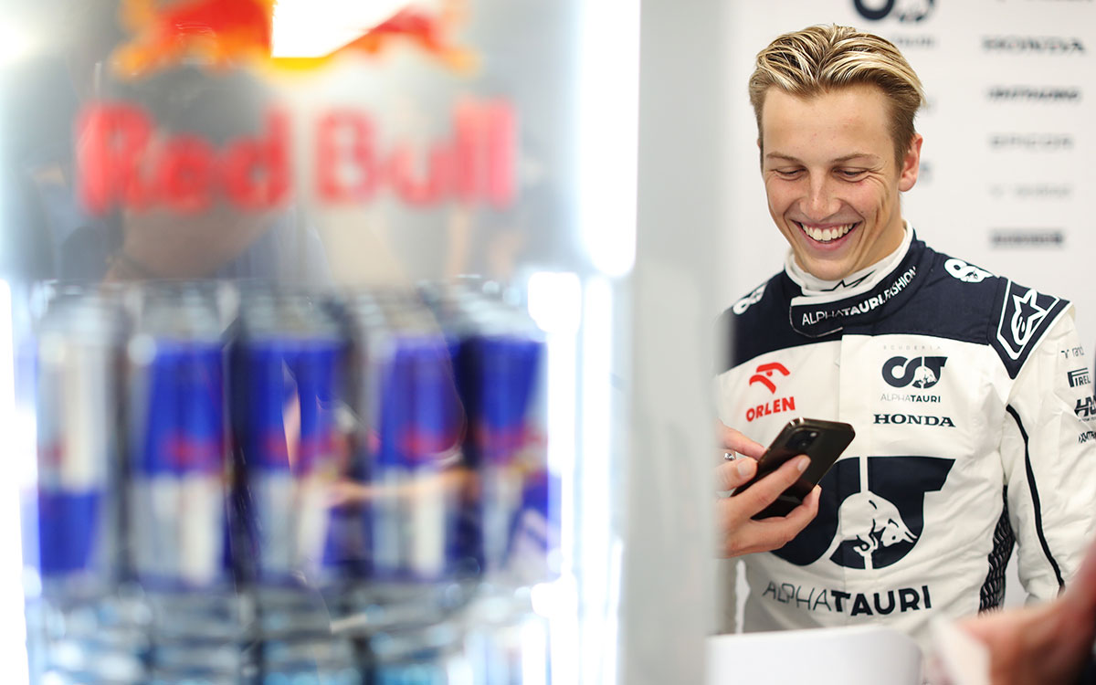 ガレージ内でスマホ手に笑顔を見せるリアム・ローソン（アルファタウリ）、2023年8月26日F1オランダGP