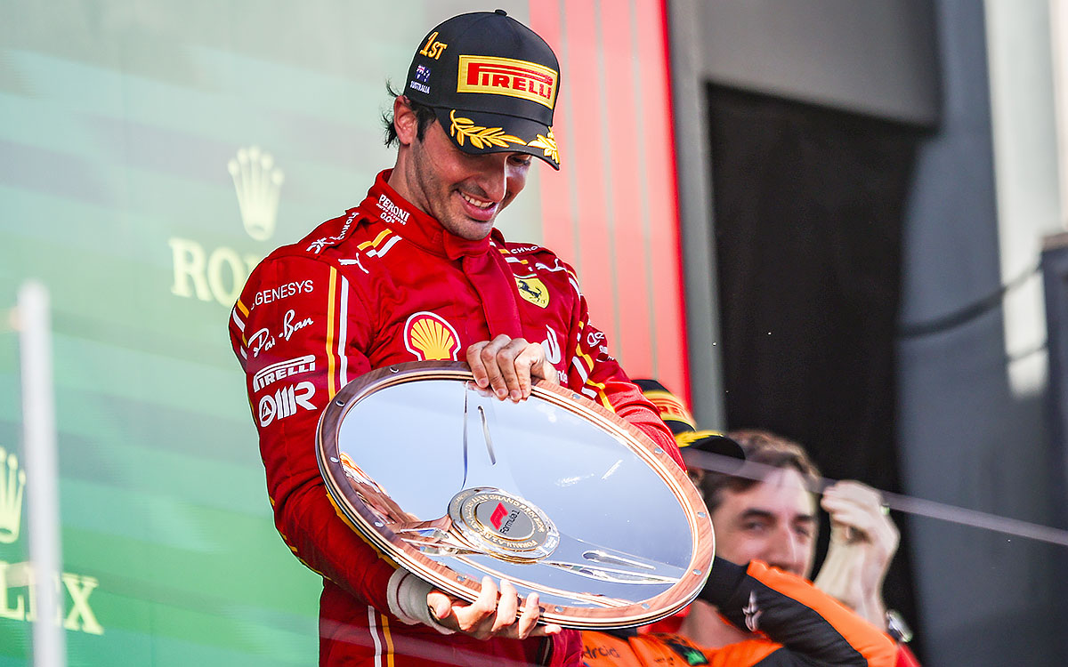 表彰台の上で優勝トロフィーを手にするカルロス・サインツ（フェラーリ）、2024年3月24日F1オーストラリアGP