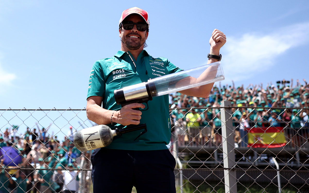 観客席の前でエアキャノンを手に笑顔を見せるフェルナンド・アロンソ（アストンマーティン・ホンダ）、2026年6月14日(日) F1バルセロナ・カタロニアGP決勝（カタロニア・サーキット）