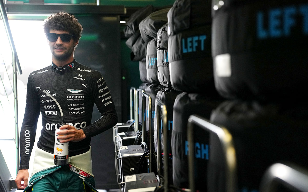 タイヤウォーマーが並ぶガレージ内をドリンクを手に歩くジャック・クロフォード(アストンマーティン・ホンダ サードドライバー)、2026年7月17日(金) F1ベルギーGPフリー走行1(スパ・フランコルシャン)