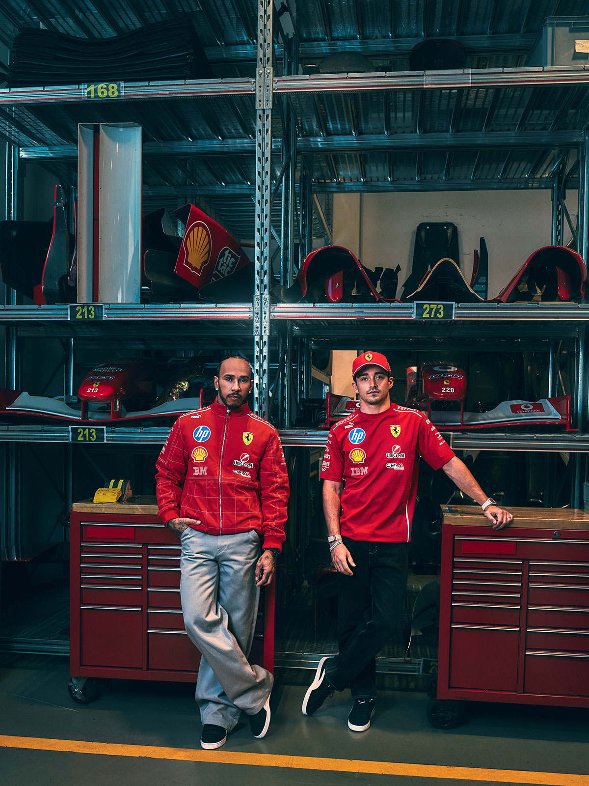 フェラーリの歴代F1マシンのパーツが並ぶ保管庫で特別仕様のチームウェアを着用するルイス・ハミルトンとシャルル・ルクレール、2026年F1イタリアGP