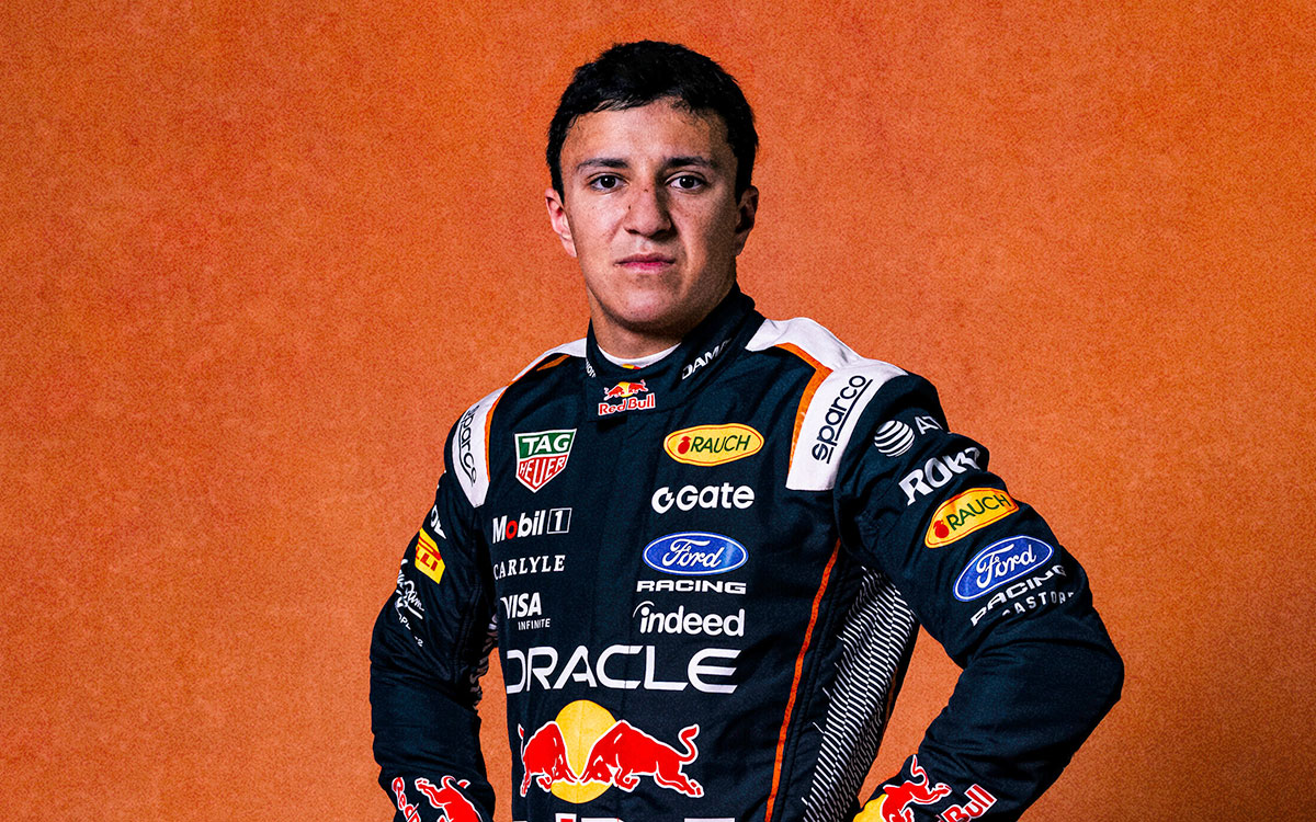 オレンジ色の背景の前で新しいオランダGP仕様のレーシングスーツを着てポーズを取るアイザック・ハジャー(レッドブル・レーシング)、2026年7月9日(木)