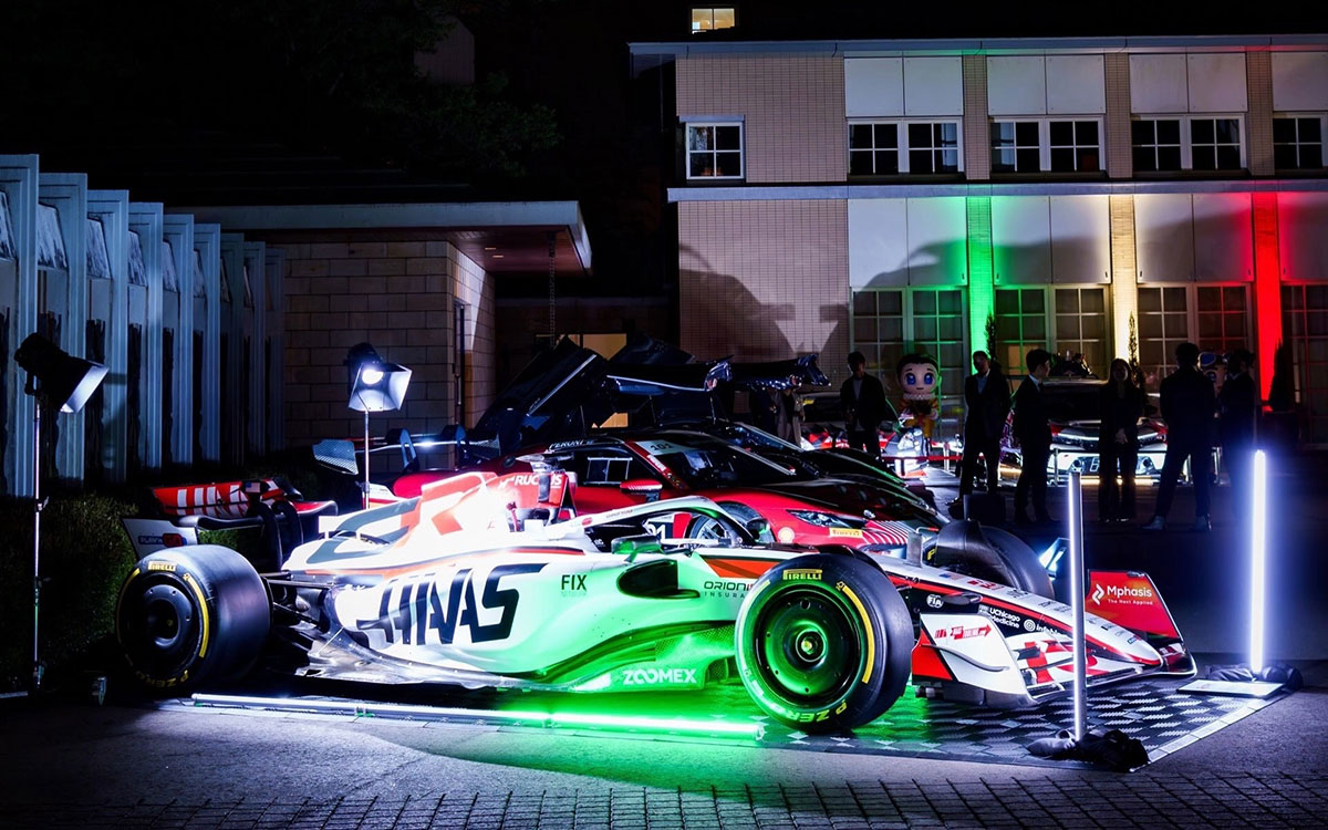 イタリア国旗の緑・白・赤をイメージした照明に照らされるハースのF1マシンと、その後方に並ぶフェラーリ296 GT3、2026年10月12日(月) 日伊外交関係樹立160周年記念「Motorsport Day 2026」（在日イタリア大使館）