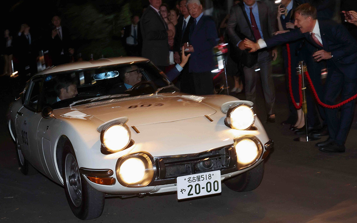 トヨタ2000GTを自ら運転してイタリア大使公邸に到着する豊田章男（トヨタ自動車会長）と助手席に乗る小松礼雄（ハースF1チーム代表）、出迎えるロニー・クインタレッリら関係者たち、2026年10月12日(月) 日伊外交関係樹立160周年記念「Motorsport Day 2026」