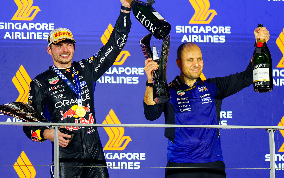 表彰台でトロフィーとシャンパンボトルを掲げて優勝を祝うマックス・フェルスタッペン(レッドブル・レーシング)とジャンピエロ・ランビアーゼ、2026年10月11日(日) F1シンガポールGP決勝(マリーナベイ市街地コース)