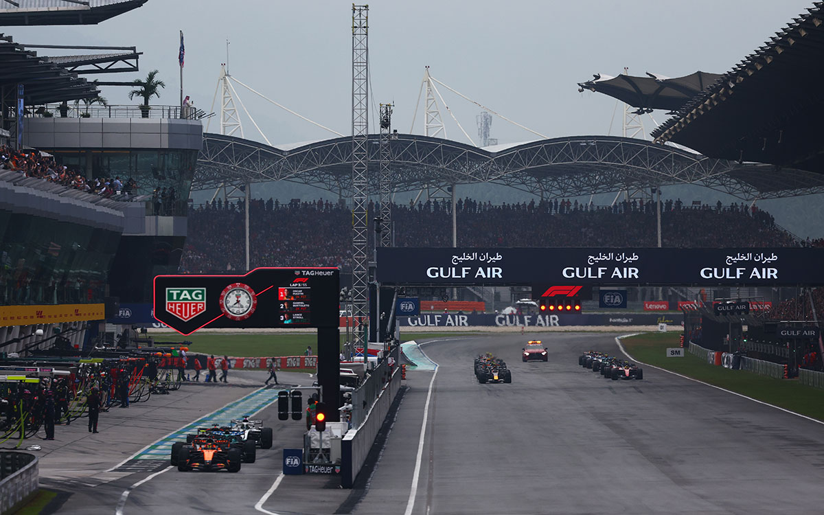 満員のグランドスタンドを背にホームストレートで決勝スタートを迎えるF1マシンの一団、2026年10月4日(日) F1バーレーンGP（セパン・インターナショナル・サーキット）