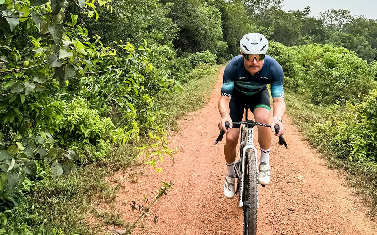 セパンの緑豊かな未舗装路を自転車で走るバルテリ・ボッタス（キャデラック）、2026年9月30日(水)
